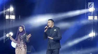 Penyanyi Siti Nurhaliza (kiri) berduet dengan Tulus dalam konser 'Dato Sri Siti Nurhaliza on Tour' di Istora Senayan, Jakarta, Kamis (21/2). Kehadiran Tulus menjadi kejutan spesial bagi penonton konser tersebut. (Fimela.com/Bambang E Ros)