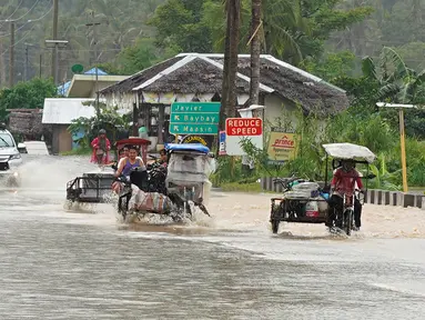 Pengendara mobil mengarungi jalan yang banjir setelah hujan lebat akibat badai tropis Agaton di Kota Abuyog, Provinsi Leyte, Filipina, 11 April 2022. (Bobbie ALOTA/AFP)