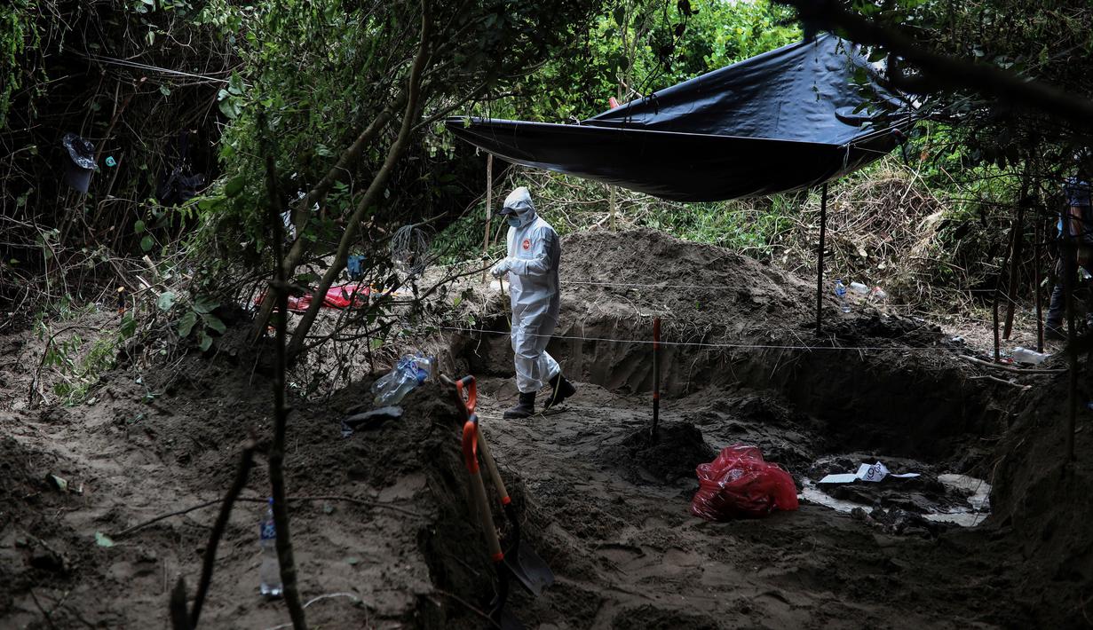 Seorang peneliti bekerja di kuburan massal rahasia di negara bagian Veracruz, Meksiko, Jumat (7/9). Jasad-jasad itu diduga kuat sebagai korban perang antargeng narkoba serta kekerasan terkait meningkatnya ekskalasi akibat kasus korupsi. (AP/Felix Marquez)