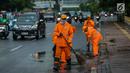 Petugas Dinas Kebersihan membersihkan genangan air usai hujan di kawasan jalan Sudirman, Jakarta, Rabu (22/11). Buruknya sistem drainase membuat petugas membersihkan genangan setiap kali hujan, meski dengan peralatan seadanya. (Liputan6.com/Faizal Fanani)
