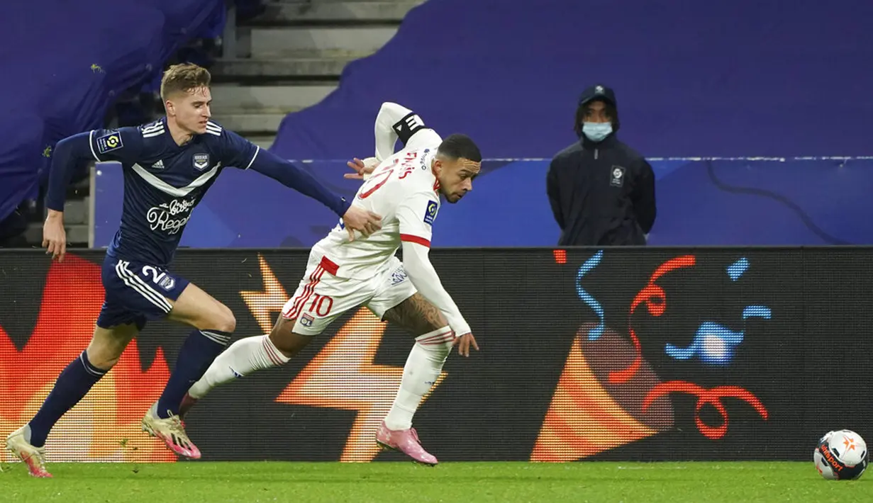 Pemain Lyon Memphis Depay (kanan) memperebutkan bola dengan pemain Bordeaux Toma Basic pada pertandingan Liga Prancis di Lyon, Prancis, Jumat (29/1/2021). Lyon menang 2-1 atas Bordeaux dan naik ke puncak klasemen sementara Liga Prancis menyalip Paris Saint-Germain (PSG). (AP Photo/Laurent Cipriani)