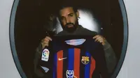 Musisi/Penyayi rap Drake 'muncul' di jersey Barcelona saat hadapi Real Madrid pada laga El Clasico di Liga Spanyol 2022/2023, Minggu (16/10/2022) malam WIB. (Dok. FC Barcelona)
