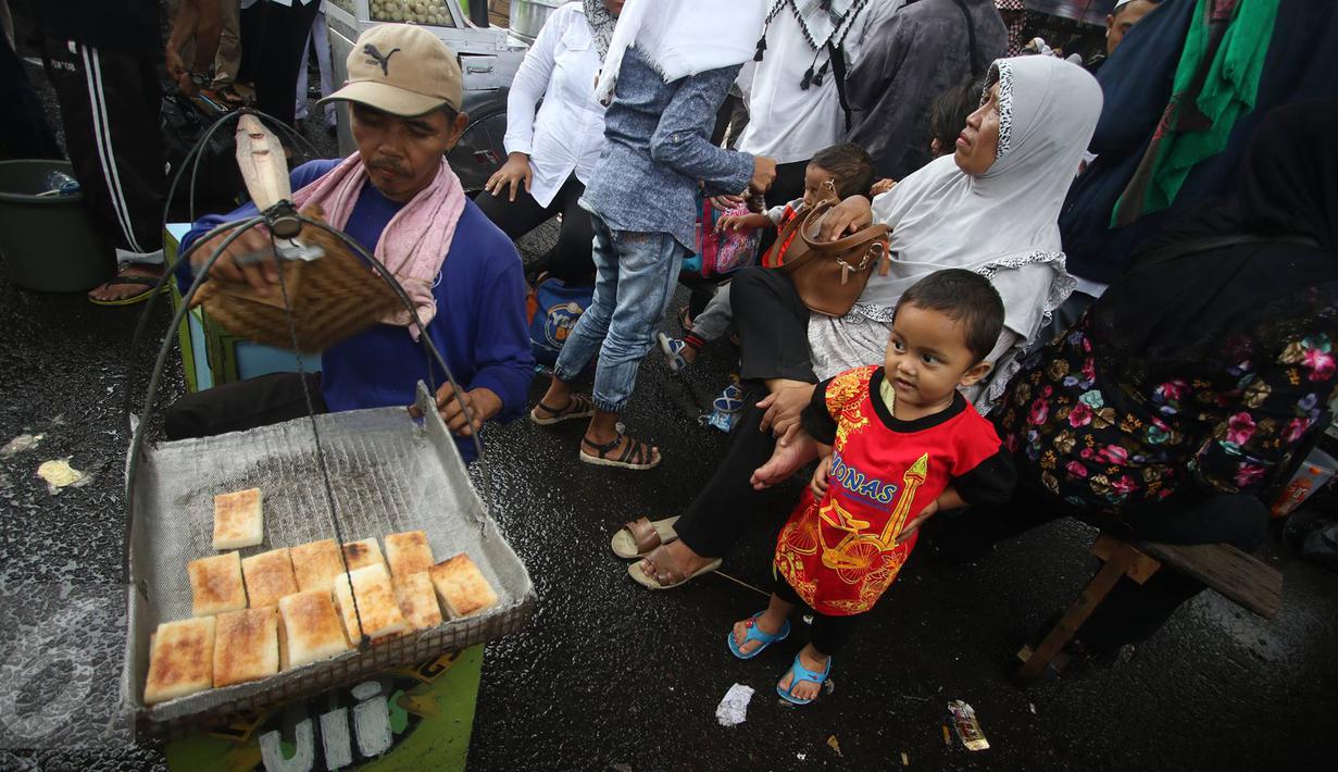 Peserta aksi damai 2 Desember membeli makanan di sekitar Mesjid Istiqlal, Jakarta, Jumat (2/12). Aksi 2 Desember yang dipenuhi massa menjadi kesempatan bagi sejumlah PKL untung meraup untung. (Liputan6.com/Immanuel Antonius)