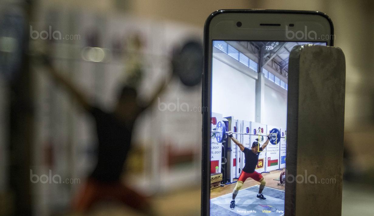 Lifter Indonesia, Deni, melakukan angkatan saat latihan di Gymnasium Sabilulungan, Jumat (21/7/2017). Tim angkat besi Indonesia melakukan persiapan jelang SEA Games 2017 Malaysia. (Bola.com/Vitalis Yogi Trisna)