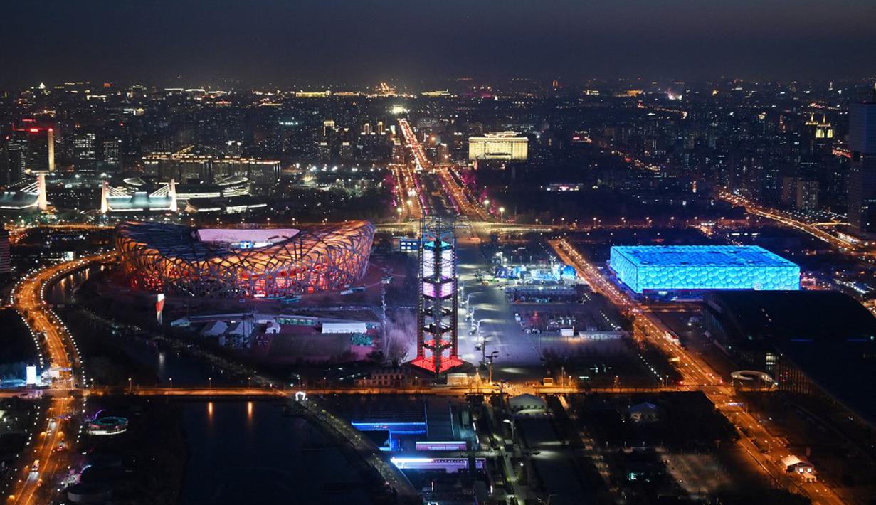 National Aquatics Center yang dikenal sebagai Ice Cube (kanan) venue untuk curling pada Olimpiade Musim Dingin 2022 dan National Stadium yang dikenal sebagai Bird's Nest (kiri) terlihat di Beijing, 3 Januari 2022. Olimpiade Musim Dingin 2022 akan dibuka pada 4 Februari mendatang. (GREG BAKER/AFP)