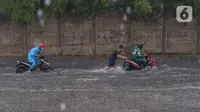 Pengendara terjebak banjir yang menggenangi jalan Bayangkara Pusdiklat, Kota Tangerang Selatan, Banten, Selasa (2/11/2021). BMKG mengeluarkan peringatan potensi cuaca ekstrem di wilayah Jakarta, Bogor, Depok, Tangerang, dan Bekasi (Jabodetabek). (Liputan6.com/Angga Yuniar)