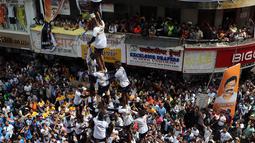 Umat Hindu membentuk piramida manusia untuk mencapai dan memecahkan dahi-handi (pot yang terbuat dari tanah liat) selama Festival Janmashtami di Mumbai, India pada 24 Agustus 2019. Festival ini menandai kelahiran dewa Krishna. (AP Photo/Rajanish Kakade)