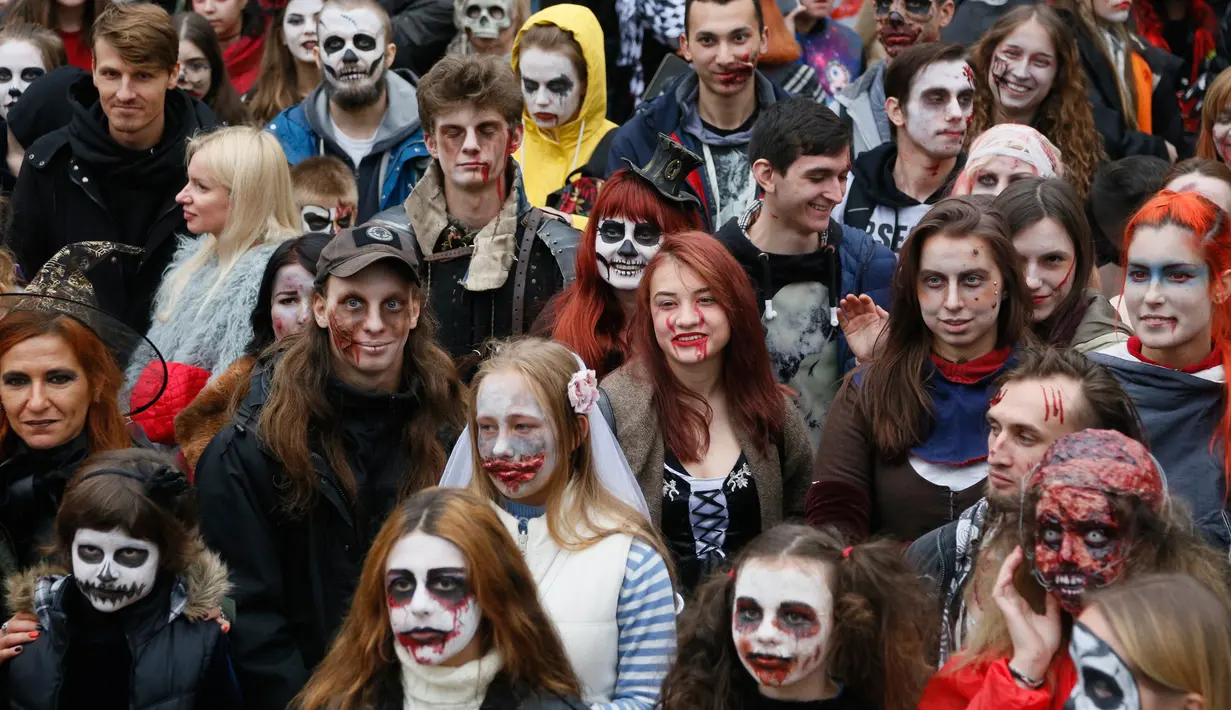 Orang-orang mengenakan kostum dan dandanan menyerupai zombie ketika berpartisipasi dalam 'Zombie Walk' di pusat Kota Kiev, Ukraina, 26 Oktober 2019. Menjelang perayaan Halloween pada 31 Oktober mendatang, warga di beberapa belahan dunia sudah mulai melakukan acara bertema horor. (AP/Efrem Lukatsky)