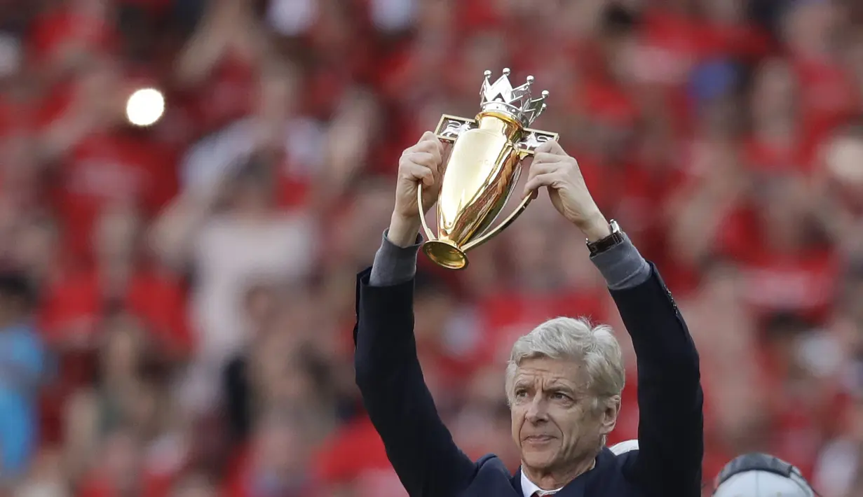 Arsene Wenger memegang trofi hadiah perpisahan di Emirates Stadium, London, (6/5/2018). Arsene Wegner mengumumkan mundur sebagai pelatih setelah 22 tahun bersama Arsenal. (AP/Matt Dunham)