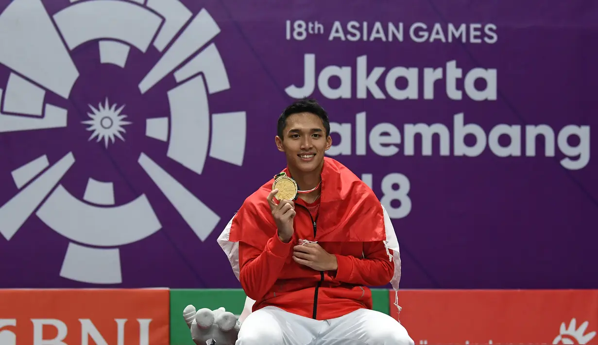 Jonatan Christie menunjukkan medali emas usai upacara penghargaan cabang olahraga badminton Asian Games 2018 di Jakarta, Selasa (28/8). Jonatan menang atas wakil Chinese Taipei, Chou Tienchen.  (AFP Photo/Sonny Tumbelaka)