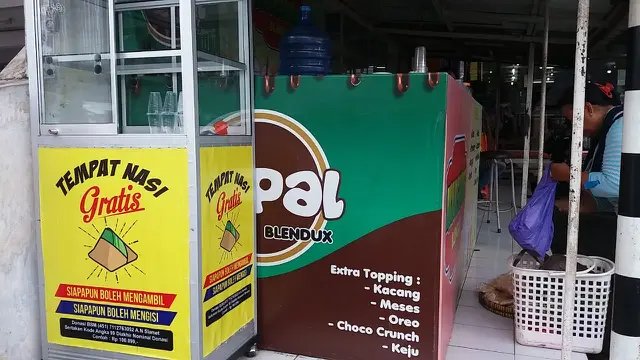 Peletakan kotak nasi gratis di pinggir jalan memudahkan dermawan bersedekah, sekaligus memudahkan kaum duafa untuk mengambil langsung. (Liputan6.com/Muhamad Ridlo)