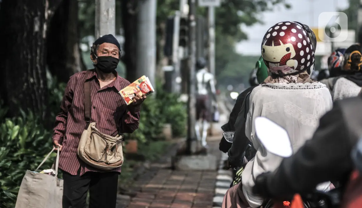 Pedagang asongan menjajakan dagangannya di lampu merah kawasan Manggarai, Jakarta, Minggu (18/10/2020). Institute for Development of Economics and Finance (Indef) memproyeksikan jumlah penduduk miskin naik 1,63 juta jiwa atau 0,56 persen selama masa pandemi Covid-19. (merdeka.com/Iqbal S. Nugroho)