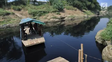 Warga menggunakan jasa penyeberangan perahu eretan di Sungai Cileungsi pebatasan Kabupaten Bogor-Kabupaten Bekasi, Bojong Kulur, Kabupaten Bogor, Jawa Barat, Selasa (23/7/2019). Perahu eretan menghubungkan Desa Bojong Kulur Bogor dan Desa Cikiwul Bekasi. (merdeka.com/Arie Basuki)