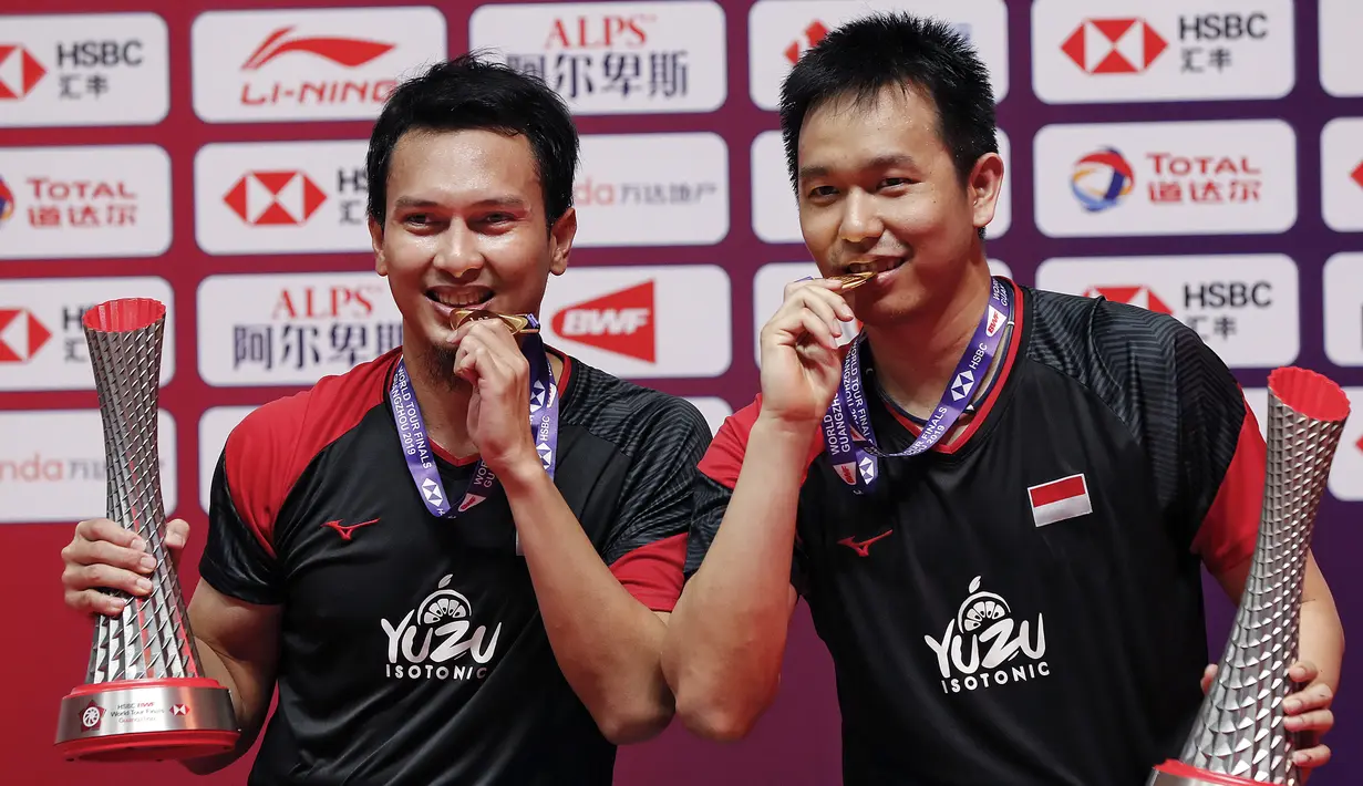 Pasangan ganda putra Mohammad Ahsan/Hendra Setiawan berpose dengan trofi dan medali seusai mengalahkan Hiroyuki Endo/Yuta Watanabe dari Jepang pada final BWF World Tour Finals 2019 di Tianhe Gymnasium, Guangzhou, China (15/12/2019). Ahsan/Hendra menang  24-22, 21-19.  (AP Photo/Andy Wong)