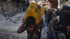 Warga Palestina membawa jerigen berisi air yang mereka kumpulkan dari sebuah truk di Kota Gaza, Kamis 16 Oktober 2025. (AP Photo/Jehad Alshrafi)