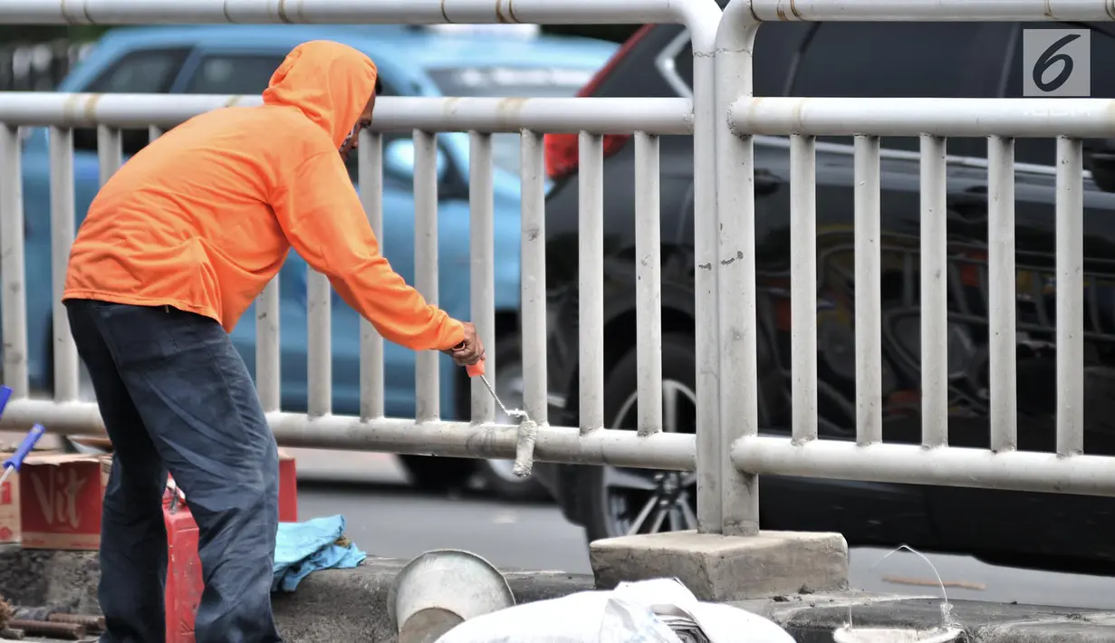 Pekerja dari Dinas Perhubungan DKI Jakarta saat mengecat pagar pembatas jalan di Jalan HOS. Cokroaminoto, Jakarta, Selasa (6/11). Pemasangan pagar bertujuan mencegah pejalan kaki menyeberang sembarangan. (Merdeka.com/ Iqbal S. Nugroho)