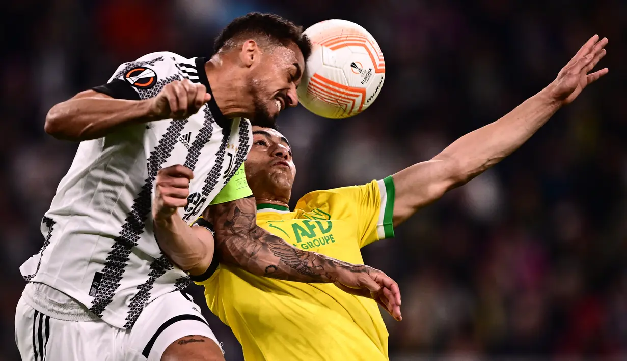 Bek Juventus Danilo (Kiri) dan penyerang Nantes Mostafa Mohamed melakukan sundulan dalam duel leg pertama play-off babak gugur Liga Europa 2022/2023 di Allianz Stadium, Jumat (17/2/2023) dini hari WIB. Hasil imbang 1-1 ini terbilang bagus bagi Nantes yang bakal meladeni Juve di markas mereka dalam duel leg kedua pekan depan. (Marco BERTORELLO / AFP)