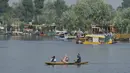 <p>Seorang pria mendayung perahu selama jam sekolah di Danau Dal di Srinagar, India, Rabu (11/5/2022). Danau terbesar di negara bagian tersebut penting untuk kegiatan perikanan, perairan, rekreasi, dan pariwisata. (TAUSEEF MUSTAFA / AFP)</p>