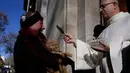 Seekor kucing mendapat berkat dari pendeta saat mengikuti upacara Saint Anthony di Madrid, Spanyol, Selasa (17/1). Ratusan hewan peliharaan dibawa pemiliknya untuk diberkati setiap tahunnya dalam upacara tersebut. (AP Photo / Daniel Ochoa de Olza)