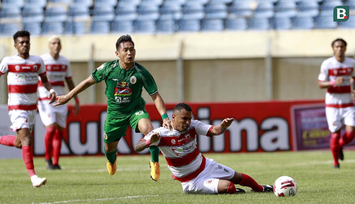 Sriker PSS Sleman, Derry Rachman (kiri) berebut bola dengan striker Madura United, Beto Goncalves dalam laga Grup C Piala Menpora 2021 di Stadion Si Jalak Harupat, Bandung, Selasa (23/3/2021). (Bola.com/M Iqbal Ichsan)