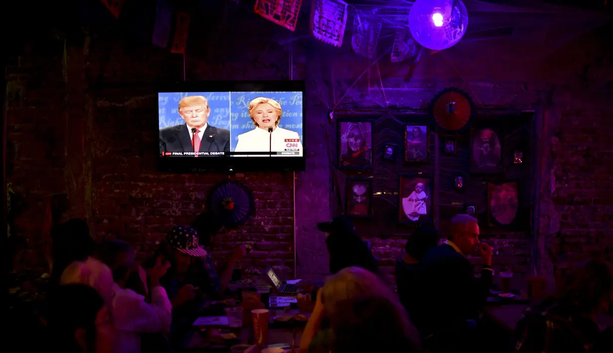Sebuah layar televisi saat menayangkan debat terakhir Capres AS Donald Trump dan Hillary Clinton di Sebuah Restoran di Meksiko, (19/10). Menurut Consulta Mitofsky Mayoritas warga Meksiko cenderung mendukung Hillary Clinton. (AFP Photo/Yuri Cortez)