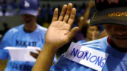 Pecandu narkoba mengambil sumpah saat bertobat di depan kepolisian di Makati, Manila, Filipina (18/8). Para pecandu narkoba menyerahkan diri lantaran marak teror penembakan misterius di Filipina. (Reuters/Eric Castro)