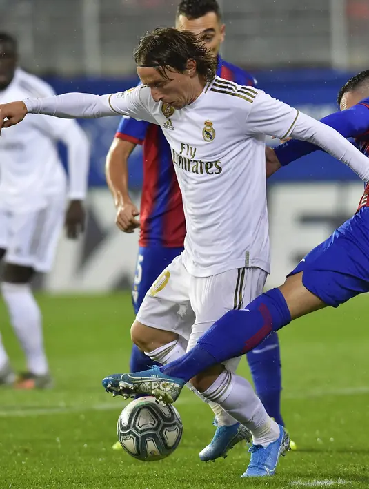 Gelandang Real Madrid, Luka Modric berusaha melewati pemain Eibar, Anaitz Arbilla pada pertandingan lanjutan Liga Spanyol di  stadion Ipurua (9/11/2019). Real Madrid menang telak 4-0 atas Eibar. (AP Photo/Alvaro Barrientos)