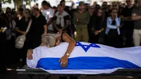 Dan kesedihan terus merebak di seluruh Israel, ketika para ibu menguburkan anak-anak mereka, bendera dan bunga berjejer di lebih banyak kuburan. (AP Photo/Francisco Seco)