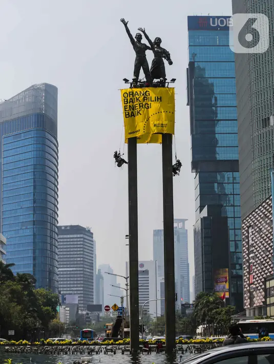 Sejumlah orang membentangkan spanduk di Patung Selamat Datang, Bundaran HI, Jakarta, Rabu (23/10/2019). Aksi ini dilakukan untuk menggalang kepedulian terhadap lingkungan Indonesia. (Liputan6.com/Faizal Fanani)