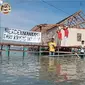Warga Desa Timbulsloko Demak menggelar upacara bendera di tengah permukiman mereka yang mulai menyatu dengan laut akibat perubahan iklim. (Liputan6.com/ Dok @timbulslokoban1)