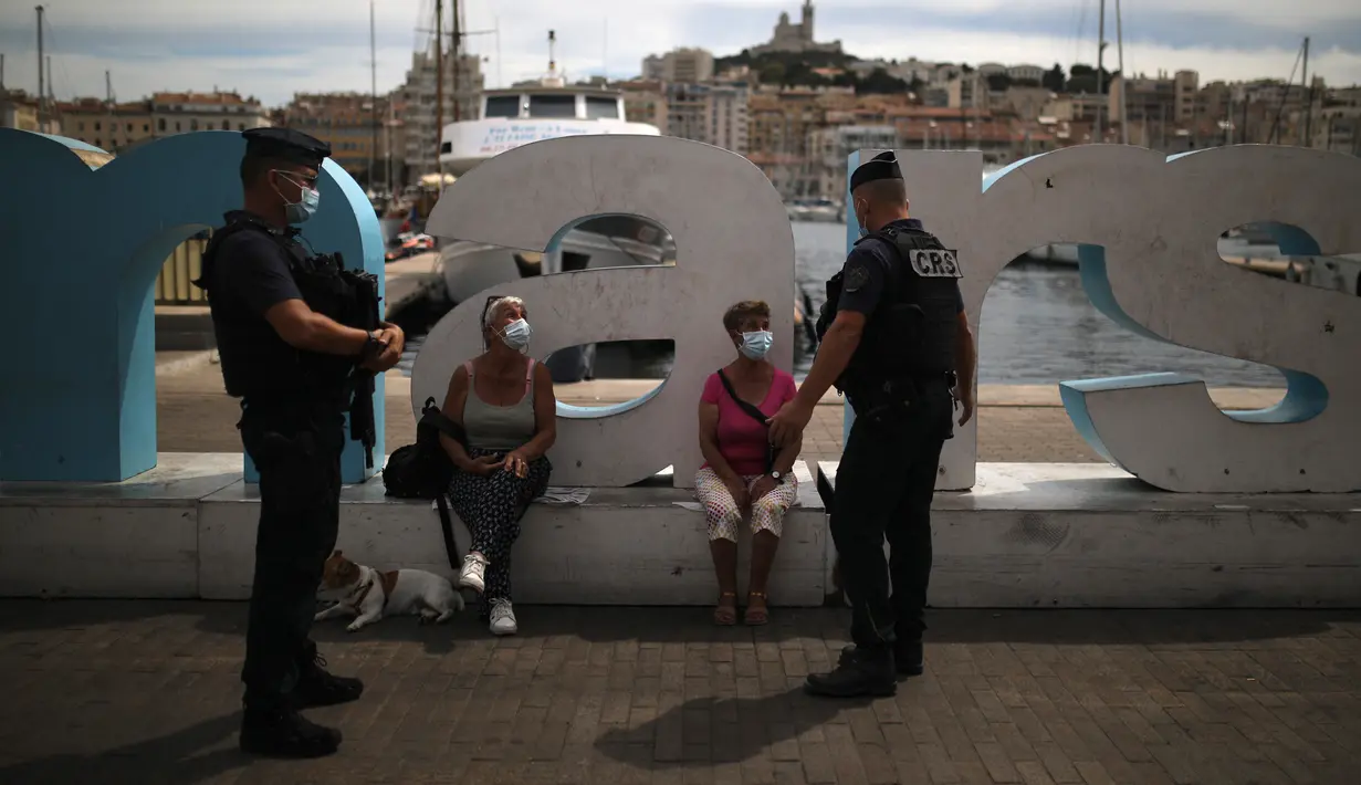 Polisi anti huru-hara Prancis berbincang dengan warga yang mengenakan masker di Marseille, Selasa (18/8/2020). Prancis mengirim polisi anti huru hara ke wilayah Marseille untuk membantu menegakkan peraturan penggunaan masker saat negara itu mencatat lonjakan kasus COVID-19. (AP Photo/Daniel Cole)