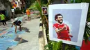 Anak-anak bermain bola di sebuah gang yang dihias  tulisan dan gambar bertemakan Piala Dunia di lingkungan rumahnya di Kinayungan, Pondok Aren, Tangerang Selatan, Kamis (28/6). (Merdeka.com/ Arie Basuki)