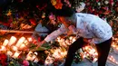 Seorang pria menyalakan lilin di lokasi terjadinya serangan truk di Stockholm, Swedia, Minggu (9/4). Sebuah truk yang dibajak menabrakkan diri ke kerumunan pejalan kaki pada Sabtu (8/4) dan menewaskan empat orang. (AP Photo / Markus Schreiber)