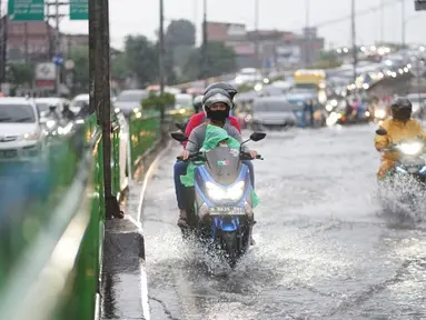 Pengendara motor menerobos banjir yang menggenangi Jalan Arif Rahman Hakim di Depok, Jawa Barat, Senin (18/5/2020). Sistem drainase buruk menjadi penyebab utama kawasan tersebut selalu tergenang banjir setiap hujan deras. (Liputan6.com/Immanuel Antonius)