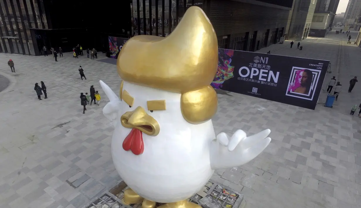 Desainer patung tersebut mengaku terinspirasi dari sosok Trump, Tiongkok, Sabtu (24/12). Pemasangan patung tersebut dilakukan untuk menyambut tahun ayam pada 2017 mendatang. (AFP PHOTO / STR)
