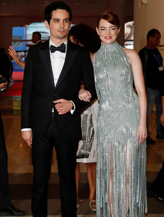 Aktris Emma Stone berpose bersama sutradara Damien Chazelle saat tiba menghadiri pembukaan Festival Film Venice ke-73 di Italia, (31/8). (REUTERS/Alessandro Bianchi)