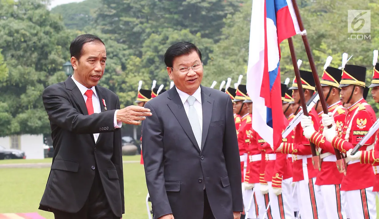 Presiden Joko Widodo (Jokowi) mendampingi PM Republik Demokratik Rakyat, Laos Thongloun Sisoulith melakukan pemeriksaan pasukan kehormatan pada upacara kenegaraan di Istana Kepresidenan Bogor, Jawa Barat, Kamis (12/10). (Liputan6.com/Angga Yuniar)