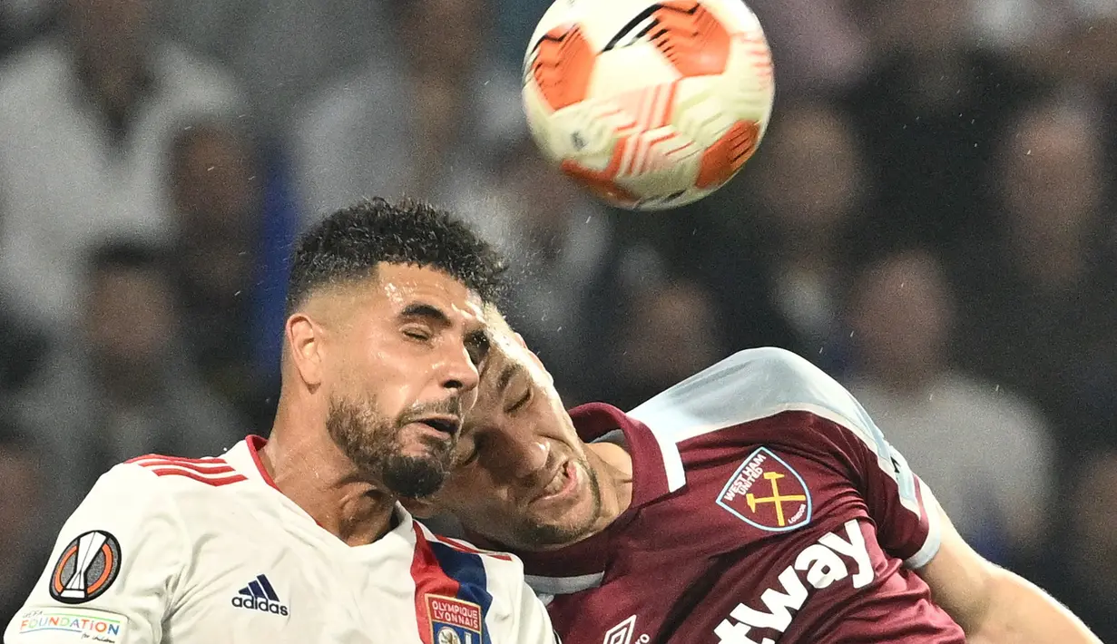 Bek Olympique Lyon Emerson Palmieri (kiri) berebut bola dengan gelandang West Ham United Tomas Soucek pada leg kedua perempat final Liga Europa melawan Lyon di Parc Olympique Lyonnais, Jumat (15/4/2022) dini hari WIB. West Ham lolos ke semifinal usai melibas tuan rumah Lyon 0-3. (Jeff PACHOUD/AFP)