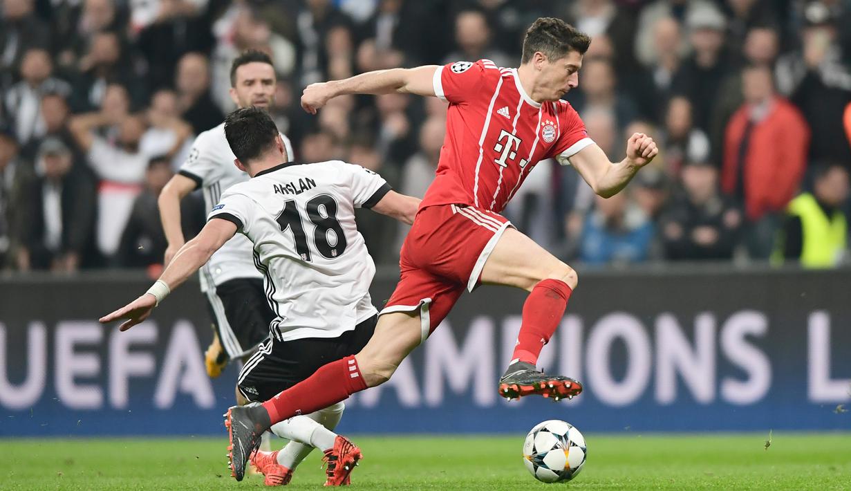 Robert Lewandowski (kanan) mencoba melewati adangan pemain Besiktas, Tolgay Arslan pada leg kedua 16 besar Liga Champions di Vodafone Stadyumu, Besiktas Park, Istanbul, (14/3/2018). Bayern menang 3-1. (AFP/Ozan Kose)