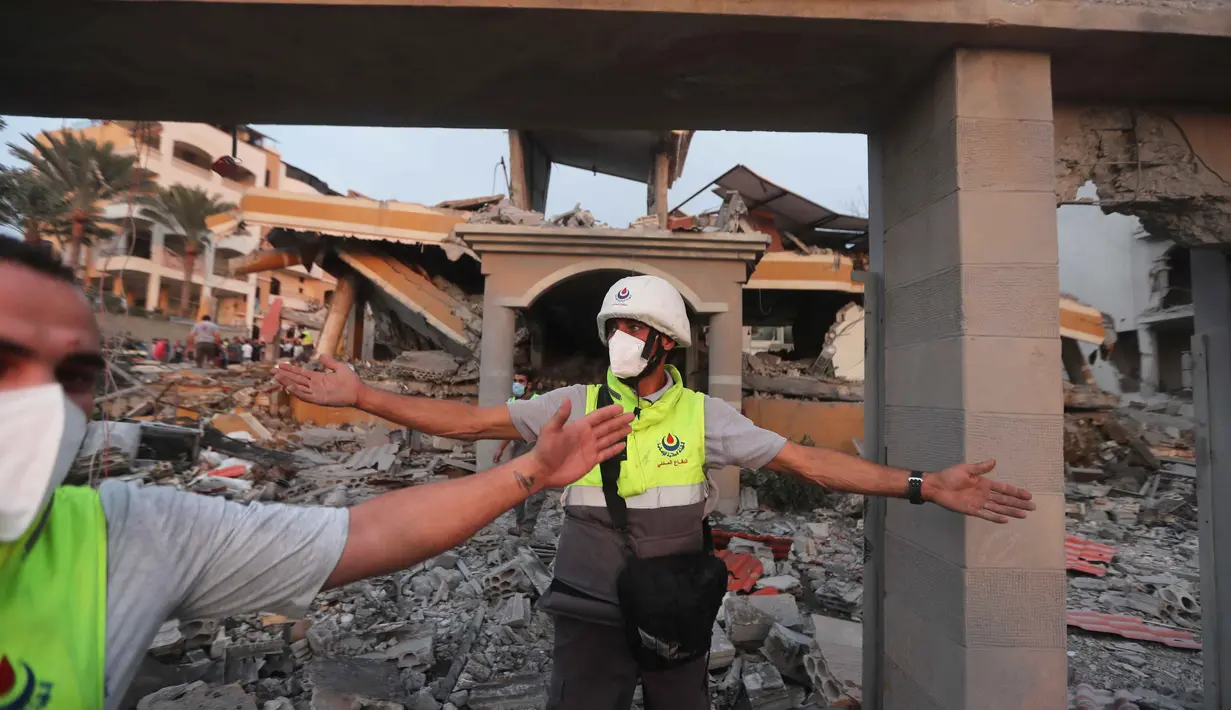 Militer Israel mengklaim serangan tersebut menargetkan infrastruktur dan posisi militer milik kelompok Hizbullah. Tampak dalam foto, anggota pertahanan sipil memblokir area di sekitar bangunan yang hancur akibat serangan udara Israel di desa Teir Debba, Lebanon Selatan, Kamis 6 November 2025. (AP Photo/Mohammad Zaatari)