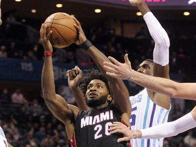 Pemain Miami Heat, Justise Winslow #20 berusaha melewati hadangan para pemain Charlotte Hornets pada laga NBA di Spectrum Center, (29/12/2016). Hornets menang 91-82. (Reuters/Sam Sharpe-USA TODAY Sports)