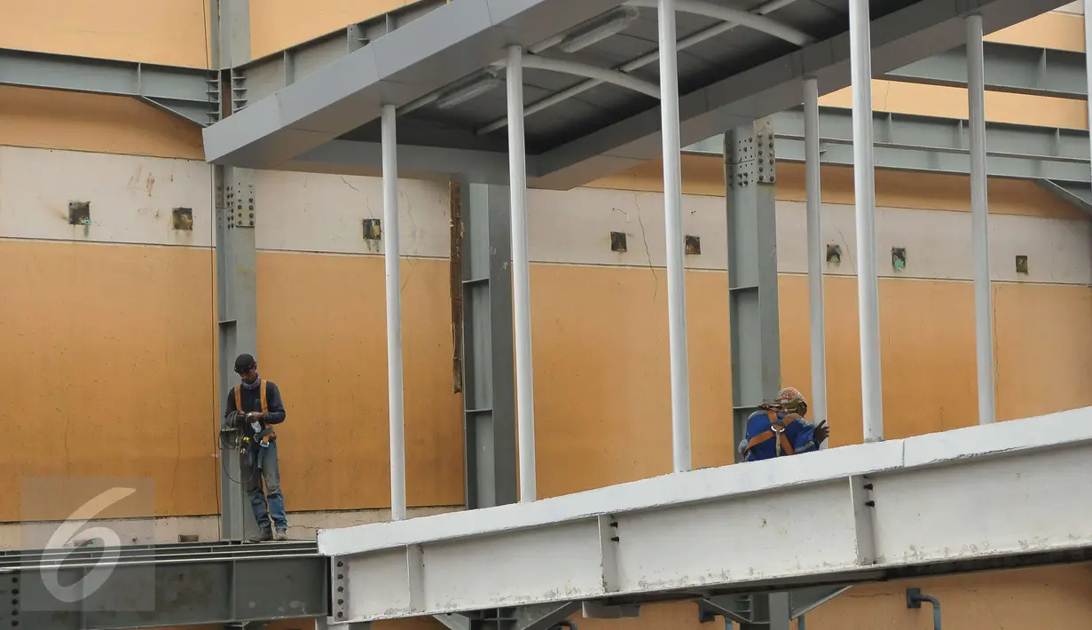 Pekerja sedang menyelesaikan pembangunan halte TransJakarta di Cipulir, Jakarta, Minggu (16/4). Meski libur paskah para pekerja tetap menyelesaikan pembangunan halte transJ yang di targetkan beroperasi sebelum Juni. (Liputan6.com/Helmi Afandi)