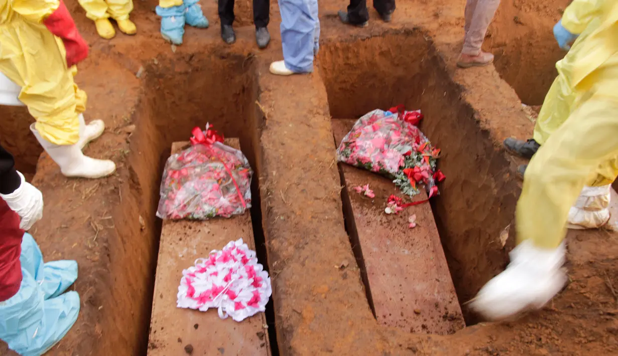 Peti jenazah korban banjir dan tanah longsor saat dimakamkan di sebuah pemakaman di Sierra Leone, Freetown, (17/8). Pemerintah setempat telah mengubur 350 orang yang tewas akibat musibah tersebut. (AP Photo/Manika Kamara)