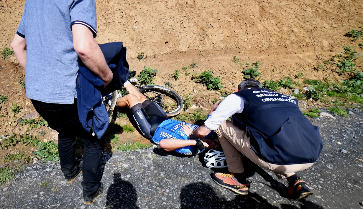 Petugas memberi perawatan CPR kepada pembalap sepeda Belgia, Michael Goolaerts setelah terjatuh saat balapan klasik Paris-Roubaix di Prancis Utara, Minggu (8/4). Goolaerts meninggal terkena serangan jantung saat balapan itu. (DAVID STOCKMAN/Belga/AFP)