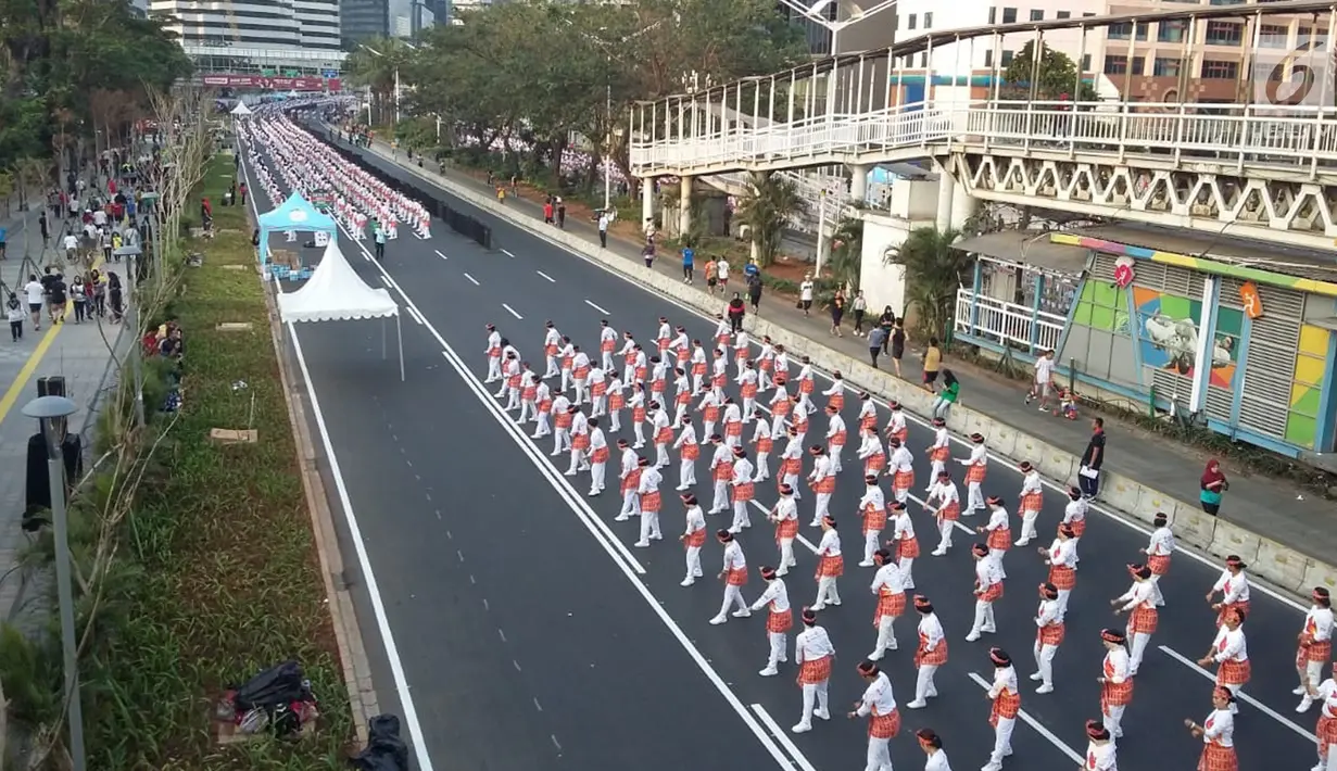 Ribuan peserta mengikuti pemecahan Guinness World Record tari Poco-poco di sepanjang Jalan MH Thamrin-Sudirman, Jakarta, Minggu (5/8). Presiden Jokowi dan Ibu Negara Iriana turut mengikuti acara ini bersama peserta. (Liputan6.com/Pool/Biro Pers Setpress)