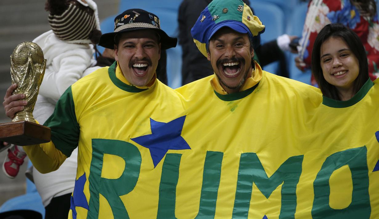 Gaya suporter Brasil dengan membawa replika Piala Dunia saat mendukung timnya melawan Ekuador pada laga kualifikasi Piala Dunia 2018 di Porto Alegre, Brasil, (31/8/2017). (AP/Leo Correa)