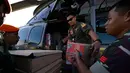Setiap harinya, pesawat dan helikopter dikerahkan dari Pangkalan Udara (Lanud) Sultan Iskandar Muda untuk menjangkau daerah-daerah yang masih terisolasi. Tampak dalam foto, personel TNI AU memuat pasokan yang akan didistribusikan kepada warga di wilayah terdampak banjir ke dalam helikopter di Pangkalan Udara (Lanud) Sultan Iskandar Muda di Blang Bintang, Aceh Besar pada Kamis 4 Desember 2025. (CHAIDEER MAHYUDDIN/AFP)