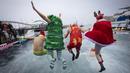 Sejumlah peserta berkostum khas hari Natal melompat ke dalam air dalam ajang Copa Nadal yang berlangsung di Barcelona's Port Vell, Barcelona, Kamis (25/12/2025) waktu setempat. Acara tersebut diikuti lebih dari 450 peserta. (AFP/Josep Lago)