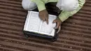 Seorang siswa muslim membaca Alquran selama bulan suci Ramadhan di Madinatul Uloom Tahfeez ul Quran, Hyderabad, India, Kamis (7/4/2022). (NOAHSELAM/AFP)