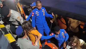 Kapal wisata berbendera Indonesia itu diketahui mengangkut 11 orang, terdiri dari awak kapal, pemandu wisata, dan penumpang, termasuk wisatawan mancanegara asal Spanyol. Tampak foto yang dirilis pada 27 Desember 2025 oleh Badan Nasional Pencarian dan Penyelamatan Indonesia (BASARNAS) Labuan Bajo ini menunjukkan anggota tim pencarian dan penyelamatan mengevakuasi wisatawan asing di perairan Pulau Padar, Labuan Bajo, Nusa Tenggara Timur, setelah sebuah kapal wisata mengalami kerusakan mesin dan tenggelam. (Handout/BASARNAS/AFP)